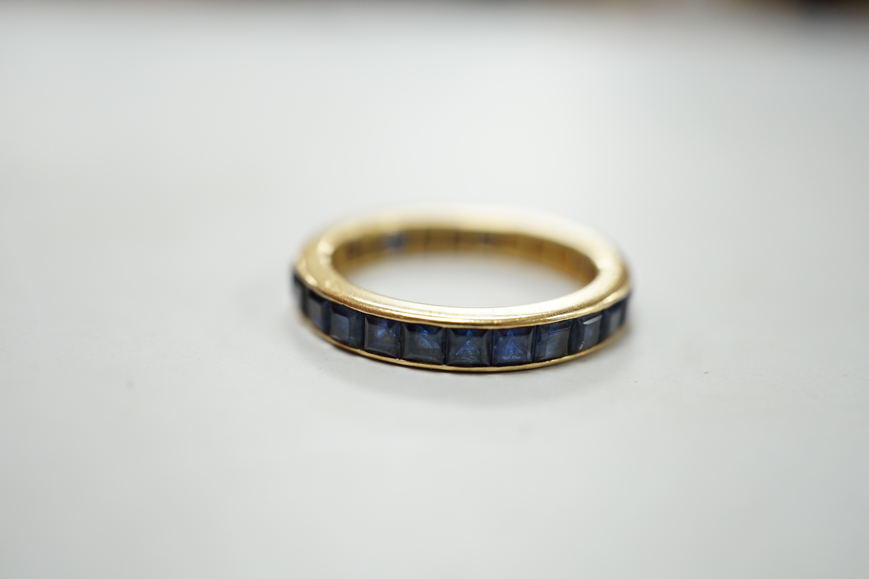 A yellow metal and sapphire set full eternity ring, size R, gross weight 4.6 grams.